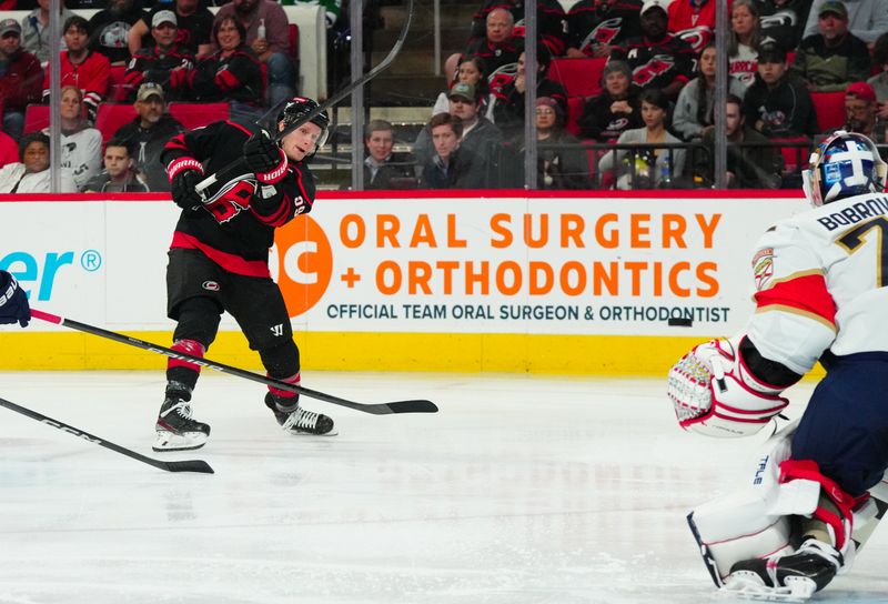 Mar 14, 2024; Raleigh, North Carolina, USA; Carolina Hurricanes left wing Jake Guentzel (59) takes a shot against the Florida Panthers during the third period at PNC Arena. Mandatory Credit: James Guillory-USA TODAY Sports