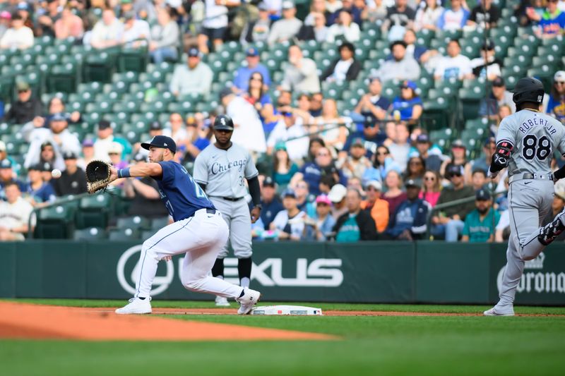 Jun 13, 2024; Seattle, Washington, USA; Seattle Mariners first baseman Tyler Locklear (27) catches a throw for a force out on Chicago White Sox center fielder Luis Robert Jr. (88) at first base during the first inning at T-Mobile Park. Mandatory Credit: Steven Bisig-USA TODAY Sports