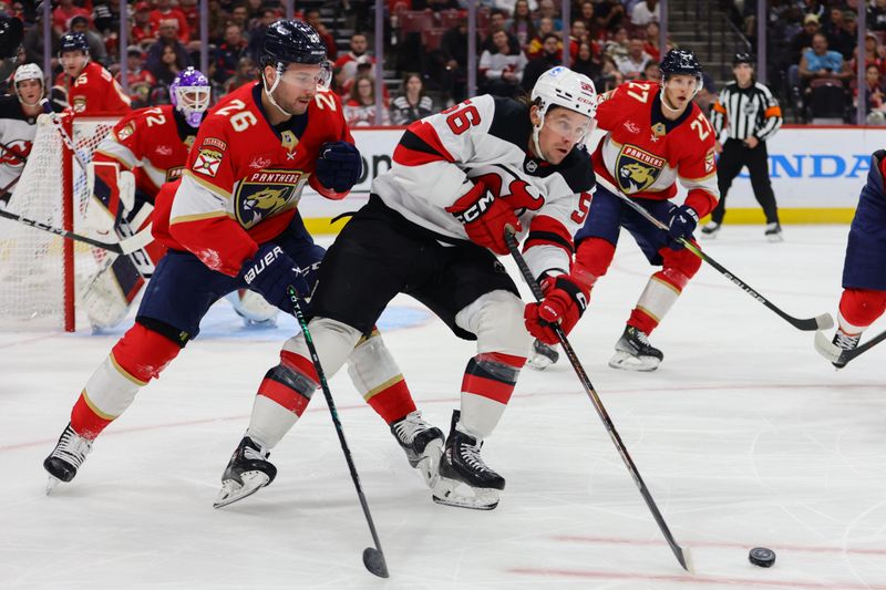 Nov 14, 2024; Sunrise, Florida, USA; New Jersey Devils left wing Erik Haula (56) moves the puck ahead of Florida Panthers defenseman Uvis Balinskis (26) during the first period at Amerant Bank Arena. Mandatory Credit: Sam Navarro-Imagn Images