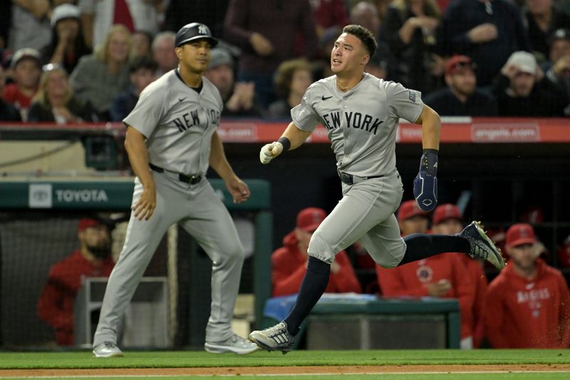 May 30, 2024; Anaheim, California, USA;  New York Yankees shortstop Anthony Volpe (11) runs home as he scores on a triple by right fielder Juan Soto (22) in the seventh inning against the Los Angeles Angels at Angel Stadium. Mandatory Credit: Jayne Kamin-Oncea-USA TODAY Sports