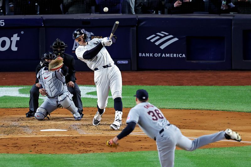 Oct 15, 2024; Bronx, New York, USA; New York Yankees outfielder Aaron Judge (99) hits an RBI sacrifice fly during the second inning against the Cleveland Guardians in game two of the ALCS for the 2024 MLB Playoffs at Yankee Stadium. Mandatory Credit: Brad Penner-Imagn Images