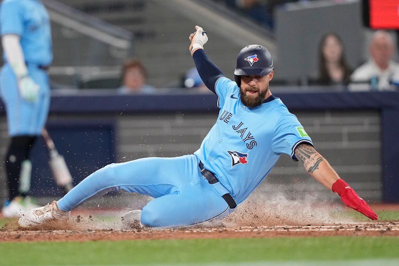 May 4, 2025; Toronto, Ontario, CAN; Toronto Blue Jays center fielder Nathan Lukes (38) slides into home plate to score on a single by second baseman Andres Gimenez (not pictured) during the fourth inning against the Cleveland Guardians at Rogers Centre. Mandatory Credit: John E. Sokolowski-Imagn Images