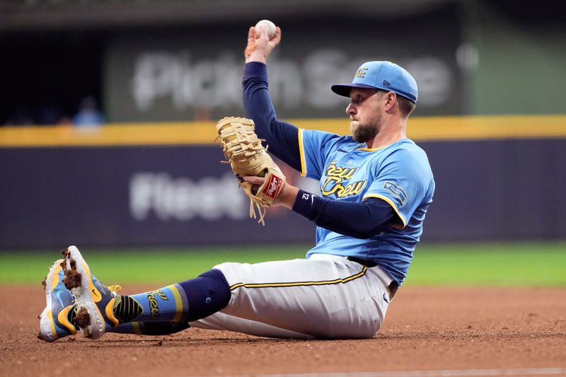 Jun 28, 2024; Milwaukee, Wisconsin, USA;  Milwaukee Brewers first baseman Rhys Hoskins (12) throws to first base during the sixth inning against the Chicago Cubs at American Family Field. Mandatory Credit: Jeff Hanisch-USA TODAY Sports