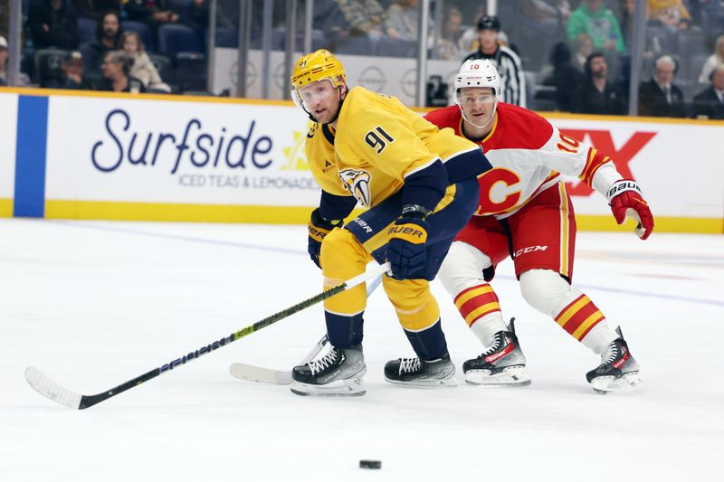 Nov 1, 2025; Nashville, Tennessee, USA; Nashville Predators center Steven Stamkos (91) receives a pass while Calgary Flames left wing Jonathan Huberdeau (10) defends during the first period against the Calgary Flames at Bridgestone Arena. Mandatory Credit: Alan Poizner-Imagn Images