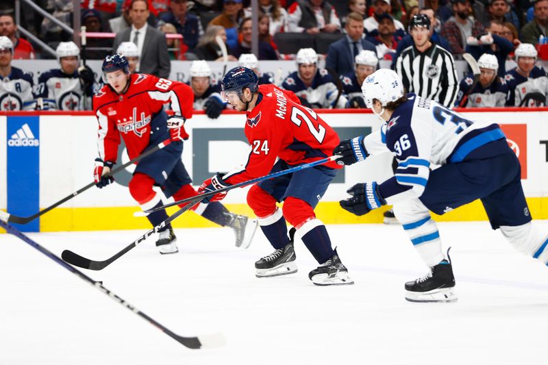 Mar 24, 2024; Washington, District of Columbia, USA; Washington Capitals center Connor McMichael (24) skates with the puck past Winnipeg Jets center Morgan Barron (36) during the first period at Capital One Arena. Mandatory Credit: Amber Searls-USA TODAY Sports