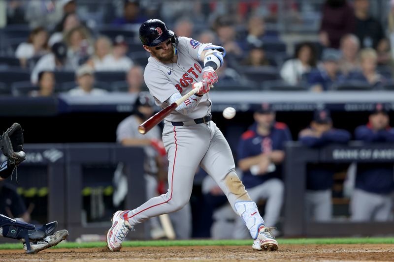 Jun 7, 2025; Bronx, New York, USA; Boston Red Sox shortstop Trevor Story (10) hits a two run single against the New York Yankees during the ninth inning at Yankee Stadium. Mandatory Credit: Brad Penner-Imagn Images