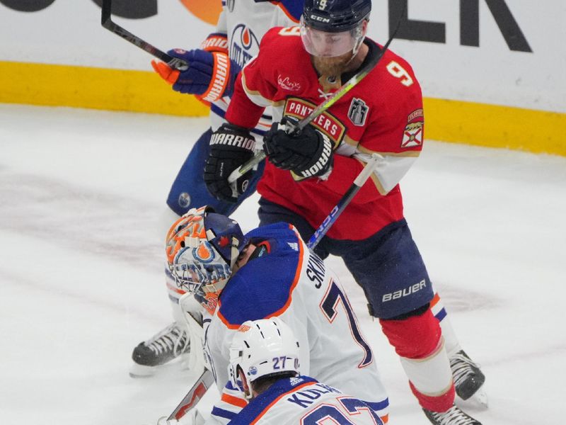 Jun 10, 2024; Sunrise, Florida, USA; Edmonton Oilers goaltender Skinner Stuart (74) and defenseman Brett Kulak (27) defend against Florida Panthers forward Sam Bennett (9) during the second period in game two of the 2024 Stanley Cup Final at Amerant Bank Arena. Mandatory Credit: Jim Rassol-USA TODAY Sports