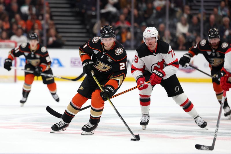 Mar 1, 2024; Anaheim, California, USA; Anaheim Ducks center Isac Lundestrom (21) skates with the puck past New Jersey Devils right wing Tyler Toffoli (73) during the second period at Honda Center. Mandatory Credit: Kiyoshi Mio-USA TODAY Sports