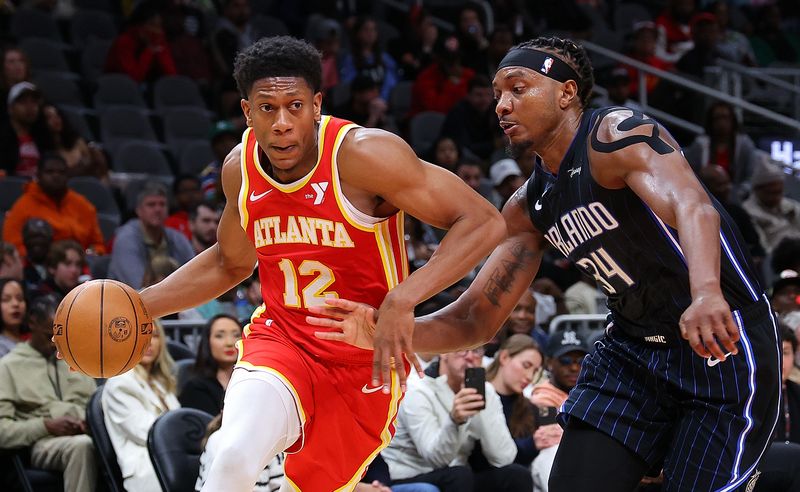 ATLANTA, GEORGIA - FEBRUARY 25:  De'Andre Hunter #12 of the Atlanta Hawks drives against Wendell Carter Jr. #34 of the Orlando Magic during the fourth quarter at State Farm Arena on February 25, 2024 in Atlanta, Georgia.  NOTE TO USER: User expressly acknowledges and agrees that, by downloading and/or using this photograph, user is consenting to the terms and conditions of the Getty Images License Agreement.  (Photo by Kevin C. Cox/Getty Images)