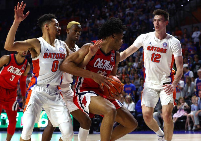 Feb 15, 2023; Gainesville, Florida, USA; Mississippi Rebels forward Jayveous McKinnis (00) drives to the basket as Florida Gators guard Myreon Jones (0) defends  during the first half at Exactech Arena at the Stephen C. O'Connell Center. Mandatory Credit: Kim Klement-USA TODAY Sports