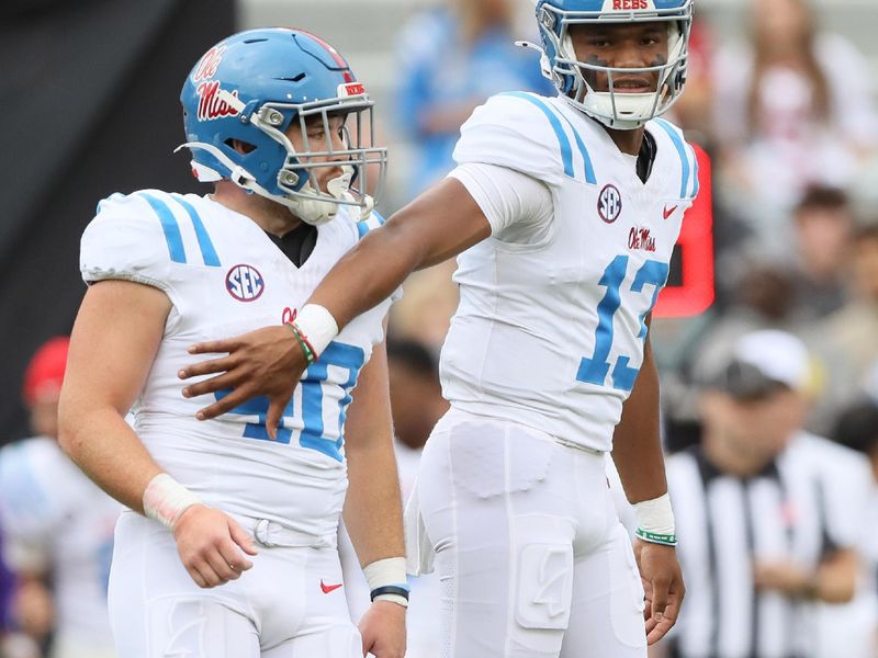 Nov 2, 2024; Fayetteville, Arkansas, USA; Ole Miss Rebels quarterback Austin Simmons (13) holds running back Jason Albritton (40) prior to a play in the fourth quarter against the Arkansas Razorbacks at Donald W. Reynolds Razorback Stadium. Mississippi won 63-31. Mandatory Credit: Nelson Chenault-Imagn Images