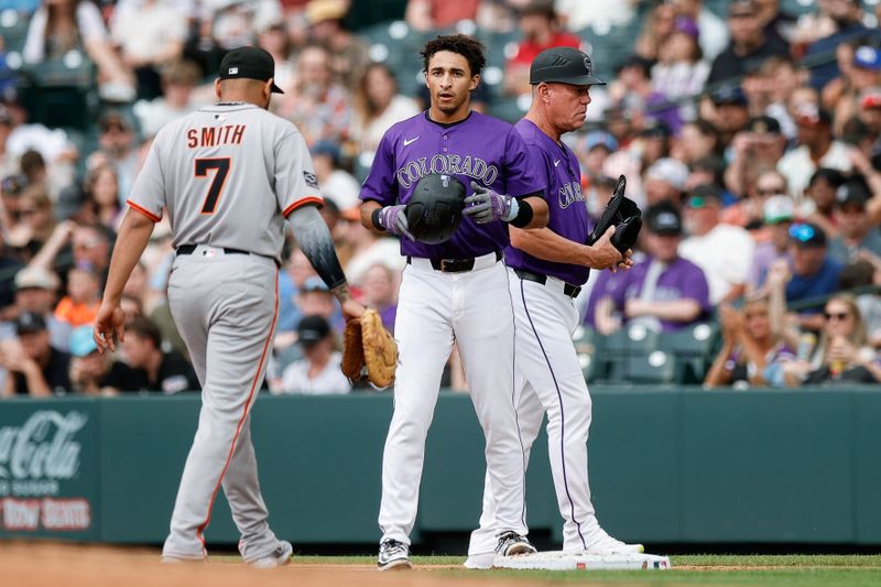 Jun 10, 2025; Denver, Colorado, USA; Colorado Rockies shortstop Ryan Ritter (8) on first ahead of first base coach Ronnie Gideon (53) and San Francisco Giants first baseman Dominic Smith (7) after an RBI single in the second inning at Coors Field. Mandatory Credit: Isaiah J. Downing-Imagn Images