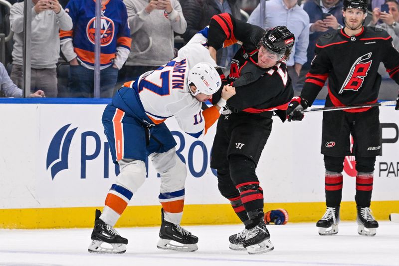 Mar 19, 2024; Elmont, New York, USA; Carolina Hurricanes left wing Brendan Lemieux (28) and New York Islanders left wing Matt Martin (17) fight during the third period at UBS Arena. Mandatory Credit: Dennis Schneidler-USA TODAY Sports