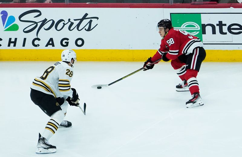 Oct 24, 2023; Chicago, Illinois, USA; Boston Bruins defenseman Derek Forbort (28) defends Chicago Blackhawks center Connor Bedard (98) during the third period at United Center. Mandatory Credit: David Banks-USA TODAY Sports