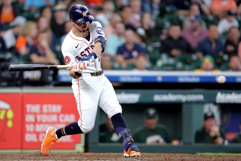May 28, 2025; Houston, Texas, USA; Houston Astros first baseman Mauricio Dubon (14) hits a single against the Athletics during the seventh inning at Daikin Park. Mandatory Credit: Erik Williams-Imagn Images