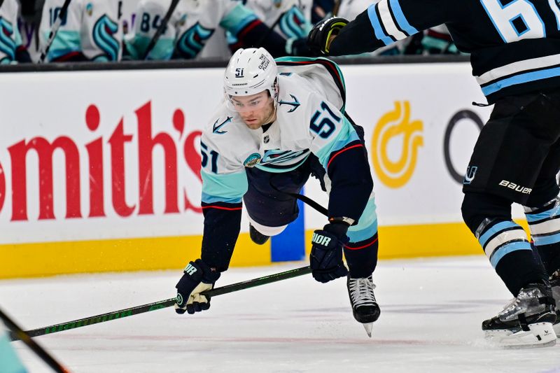 Jan 17, 2026; Salt Lake City, Utah, USA; Seattle Kraken center Shane Wright (51) trips while trying to secure the puck from Utah Mammoth left wing Lawson Crouse (67) during the second period at Delta Center. Mandatory Credit: Peter Creveling-Imagn Images