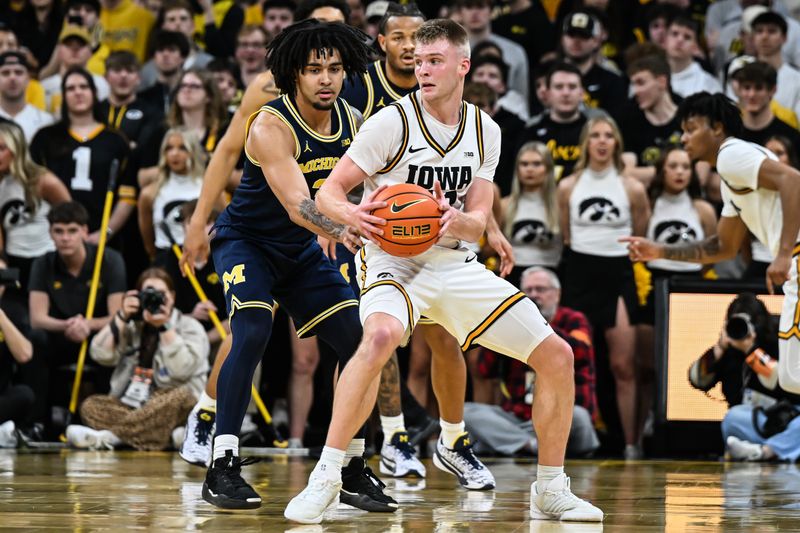 Mar 5, 2026; Iowa City, Iowa, USA; Iowa Hawkeyes guard Bennett Stirtz (14) is defended by Michigan Wolverines guard Elliot Cadeau (3) during the first half at Carver-Hawkeye Arena. Mandatory Credit: Jeffrey Becker-Imagn Images