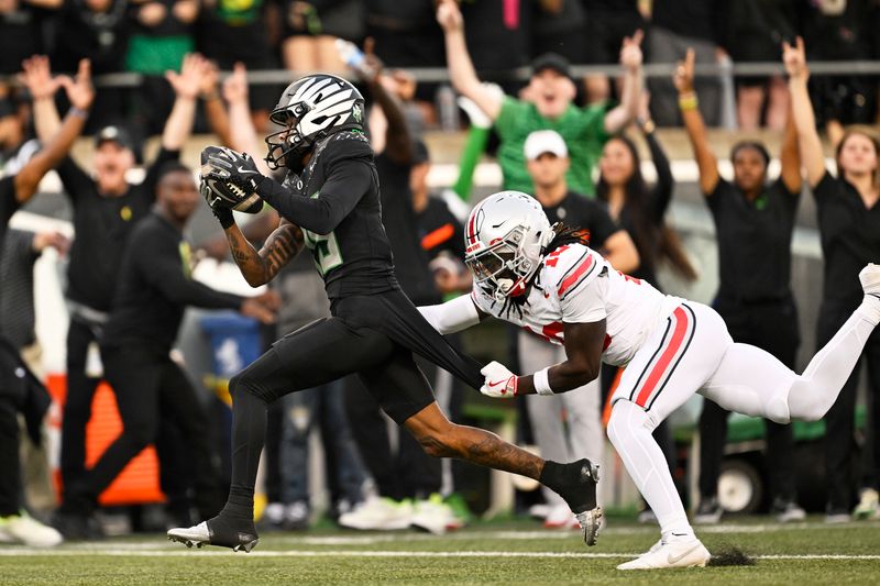 Oct 12, 2024; Eugene, Oregon, USA; Oregon Ducks wide receiver Tez Johnson (15) catches a touchdown pass against Ohio State Buckeyes cornerback Denzel Burke (10) during the first half at Autzen Stadium. Mandatory Credit: Troy Wayrynen-Imagn Images