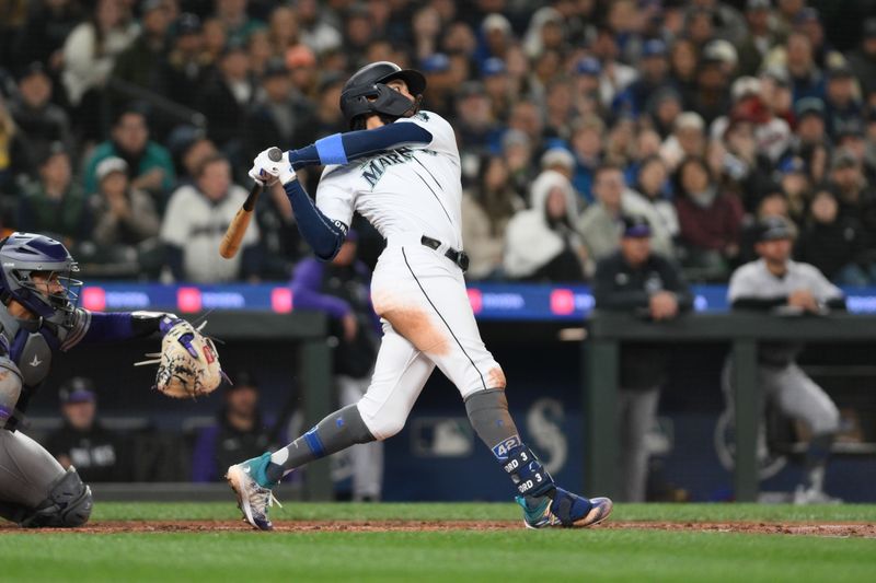 Apr 15, 2023; Seattle, Washington, USA; Seattle Mariners shortstop J.P. Crawford (3) hits a RBI single against the Colorado Rockies during the fourth inning at T-Mobile Park. Mandatory Credit: Steven Bisig-USA TODAY Sports