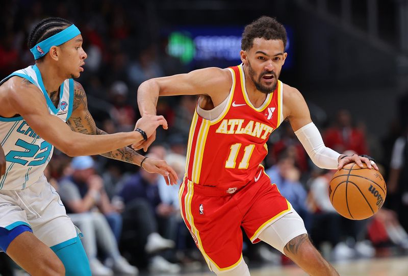 ATLANTA, GEORGIA - APRIL 10:  Trae Young #11 of the Atlanta Hawks drives against Tre Mann #23 of the Charlotte Hornets during the first quarter at State Farm Arena on April 10, 2024 in Atlanta, Georgia.  NOTE TO USER: User expressly acknowledges and agrees that, by downloading and/or using this photograph, user is consenting to the terms and conditions of the Getty Images License Agreement.  (Photo by Kevin C. Cox/Getty Images)