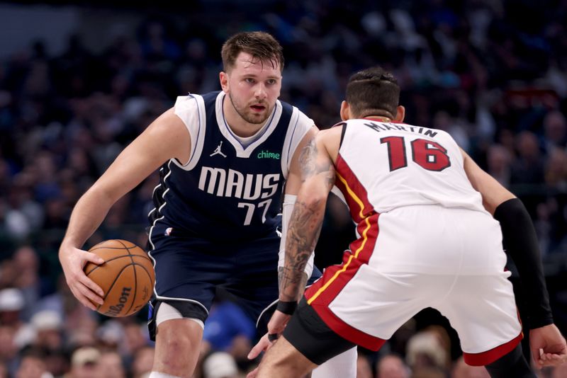 DALLAS, TEXAS - MARCH 07: Luka Doncic #77 of the Dallas Mavericks dribbles the ball against Caleb Martin #16 of the Miami Heat int he second half at American Airlines Center on March 07, 2024 in Dallas, Texas.  NOTE TO USER: User expressly acknowledges and agrees that, by downloading and or using this photograph, User is consenting to the terms and conditions of the Getty Images License Agreement. (Photo by Tim Heitman/Getty Images)