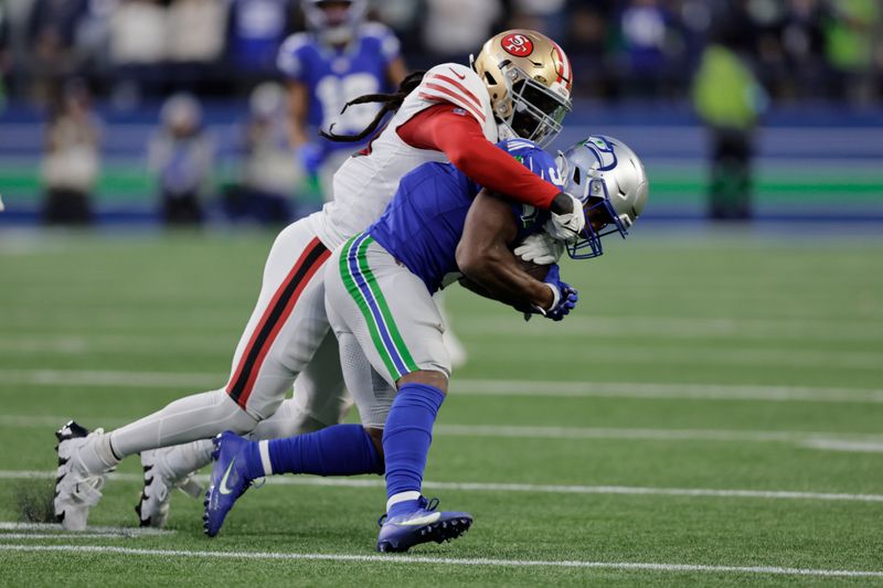 Seattle Seahawks running back Kenneth Walker III (9) is tailed by San Francisco 49ers' Fred Warner (54) during the first half of an NFL football game, Thursday, Oct. 10, 2024, in Seattle. (AP Photo/John Froschauer)