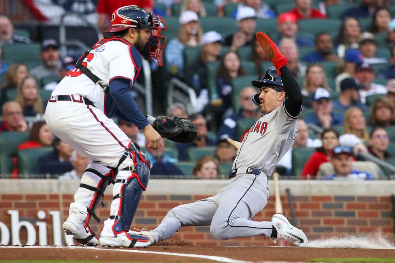 Apr 6, 2024; Atlanta, Georgia, USA; Arizona Diamondbacks center fielder Corbin Carroll (7) slides safely past Atlanta Braves catcher Travis d'Arnaud (16) to score a run in the first inning at Truist Park. Mandatory Credit: Brett Davis-USA TODAY Sports