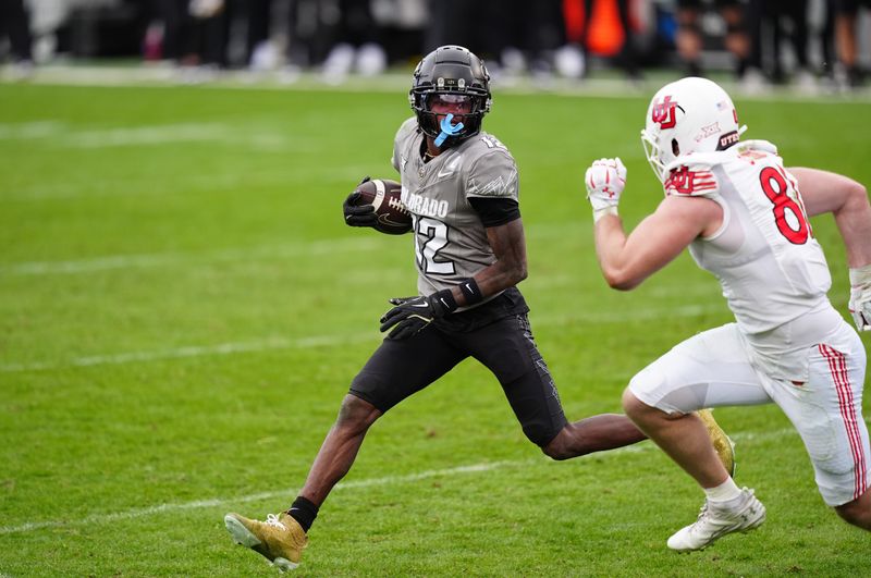Nov 16, 2024; Boulder, Colorado, USA; Colorado Buffaloes wide receiver Travis Hunter (12) carries the ball for a touchdown in the fourth quarter against the Utah Utes at Folsom Field. Mandatory Credit: Ron Chenoy-Imagn Images