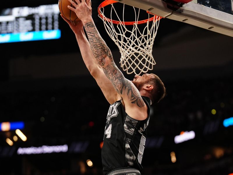 SAN ANTONIO, TX - MARCH 14:  Sandro Mamukelashvili #54 of the San Antonio Spurs dunks the ball during the game against the Charlotte Hornets on March 14, 2025 at the Frost Bank Center in San Antonio, Texas. NOTE TO USER: User expressly acknowledges and agrees that, by downloading and or using this photograph, user is consenting to the terms and conditions of the Getty Images License Agreement. Mandatory Copyright Notice: Copyright 2025 NBAE (Photos by Darren Carroll/NBAE via Getty Images)