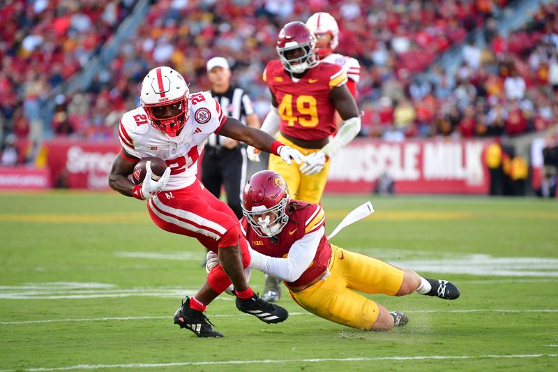 Nov 16, 2024; Los Angeles, California, USA; Nebraska Cornhuskers defensive back Dwight Bootle II (21) moves the ball against Southern California Trojans linebacker Mason Cobb (13) during the second half at the Los Angeles Memorial Coliseum. Mandatory Credit: Gary A. Vasquez-Imagn Images
