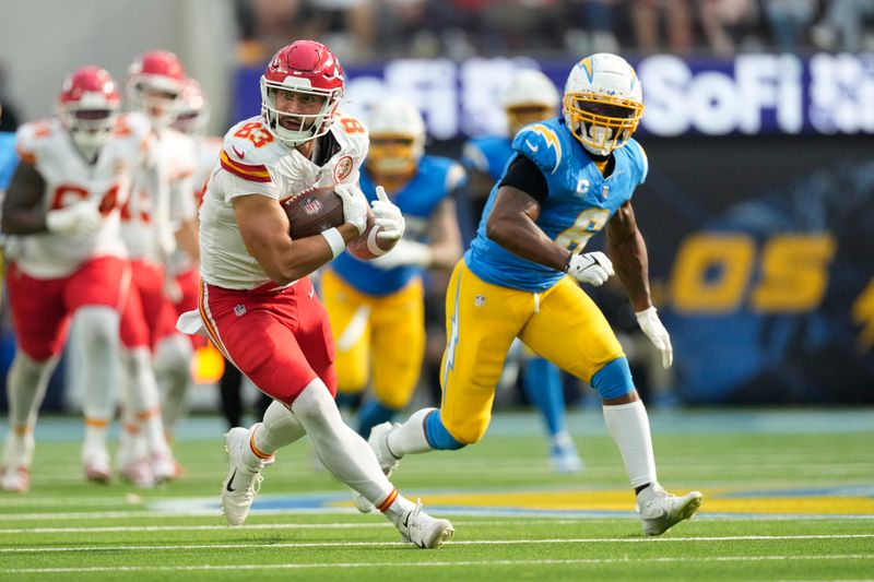 Kansas City Chiefs tight end Noah Gray (83) catches a pass as Los Angeles Chargers linebacker Denzel Perryman (6) defends during the second half of an NFL football game Sunday, Sept. 29, 2024, in Inglewood, Calif. (AP Photo/Ashley Landis)