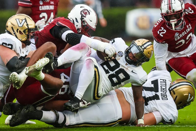 Nov 11, 2023; Columbia, South Carolina, USA; Vanderbilt Commodores running back Sedrick Alexander (28) is tackled by South Carolina Gamecocks defenders in the second quarter at Williams-Brice Stadium. Mandatory Credit: Jeff Blake-USA TODAY Sports