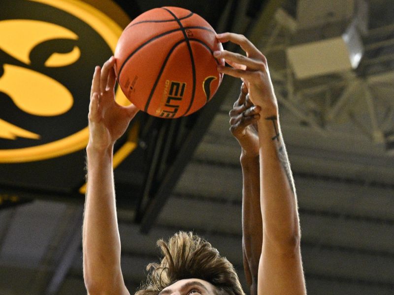 Feb 2, 2024; Iowa City, Iowa, USA; Iowa Hawkeyes forward Owen Freeman (32) grabs the rebound in front of Ohio State Buckeyes center Felix Okpara (34) during the first half at Carver-Hawkeye Arena. Mandatory Credit: Jeffrey Becker-USA TODAY Sports