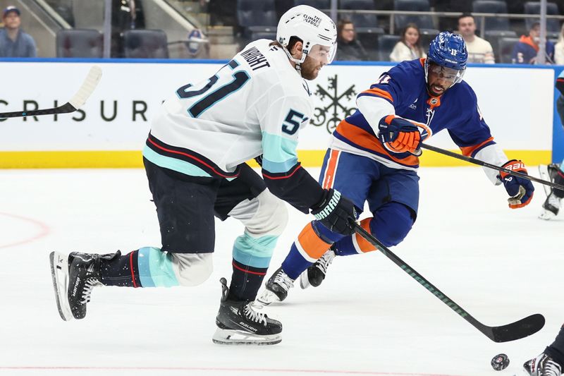 Nov 23, 2025; Elmont, New York, USA;  New York Islanders left wing Anders Lee (27) and Seattle Kraken right wing Eeli Tolvanen (20) battle for control of the puck in the third period at UBS Arena. Mandatory Credit: Wendell Cruz-Imagn Images