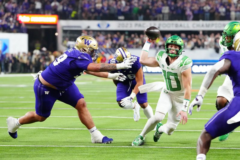 Dec 1, 2023; Las Vegas, NV, USA; Oregon Ducks quarterback Bo Nix (10) is flushed from the pocket by Washington Huskies defensive lineman Faatui Tuitele (99) during the third quarter at Allegiant Stadium. Mandatory Credit: Stephen R. Sylvanie-USA TODAY Sports