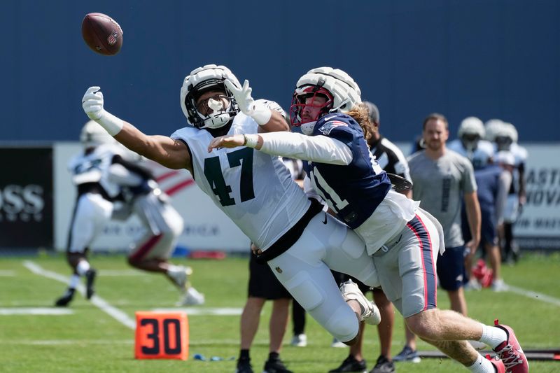 New England Patriots safety Brenden Schooler (41) breaks up a pass intended for Philadelphia Eagles tight end Armani Rogers (47) during a joint NFL football practice, Tuesday, Aug. 13, 2024, in Foxborough, Mass. (AP Photo/Michael Dwyer)