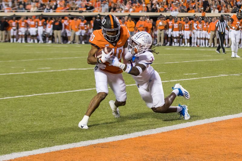 Oct 30, 2021; Stillwater, Oklahoma, USA;  Oklahoma State Cowboys wide receiver Brennan Presley (80) fights his way to the end zone for a touchdown as Kansas Jayhawks safety Ricky Thomas Jr. (3) is unable to stop him during the first quarter at Boone Pickens Stadium. Mandatory Credit: Brett Rojo-USA TODAY Sports
