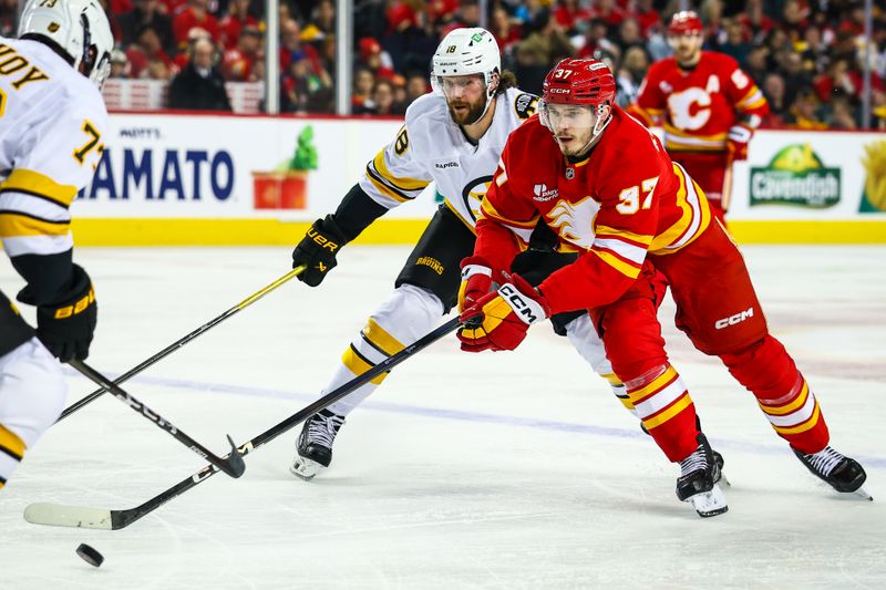 Dec 29, 2025; Calgary, Alberta, CAN; Calgary Flames defenseman Yan Kuznetsov (37) controls the puck against the Boston Bruins during the second period at Scotiabank Saddledome. Mandatory Credit: Sergei Belski-Imagn Images