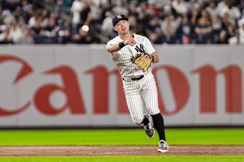 Sep 27, 2024; Bronx, New York, USA; New York Yankees shortstop Anthony Volpe (11) fields a ground ball and throws to first base for an out during the sixth inning against the Pittsburgh Pirates at Yankee Stadium. Mandatory Credit: John Jones-Imagn Images