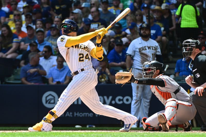 May 28, 2023; Milwaukee, Wisconsin, USA;  Milwaukee Brewers catcher William Contreras (24) hits a two-run home run in the second inning as San Francisco Giants catcher Blake Sabol (2) look on at American Family Field. Mandatory Credit: Benny Sieu-USA TODAY Sports