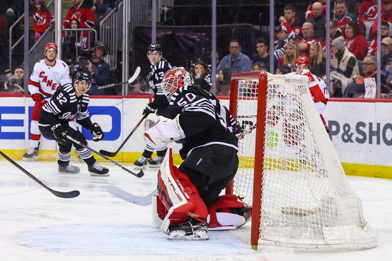 Mar 9, 2024; Newark, New Jersey, USA; Carolina Hurricanes center Jesperi Kotkaniemi (82) scores a goal on New Jersey Devils goaltender Nico Daws (50) during the third period at Prudential Center. Mandatory Credit: Ed Mulholland-USA TODAY Sports