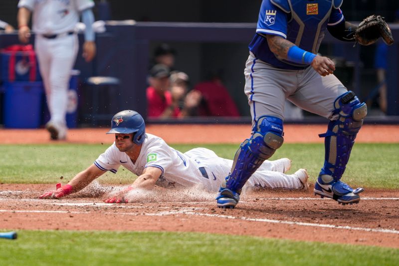 Aug 3, 2025; Toronto, Ontario, CAN; Toronto Blue Jays third base Ernie Clement (22) slides into home plate against the Kansas City Royals during the fifth inning at Rogers Centre. Mandatory Credit: Kevin Sousa-Imagn Images