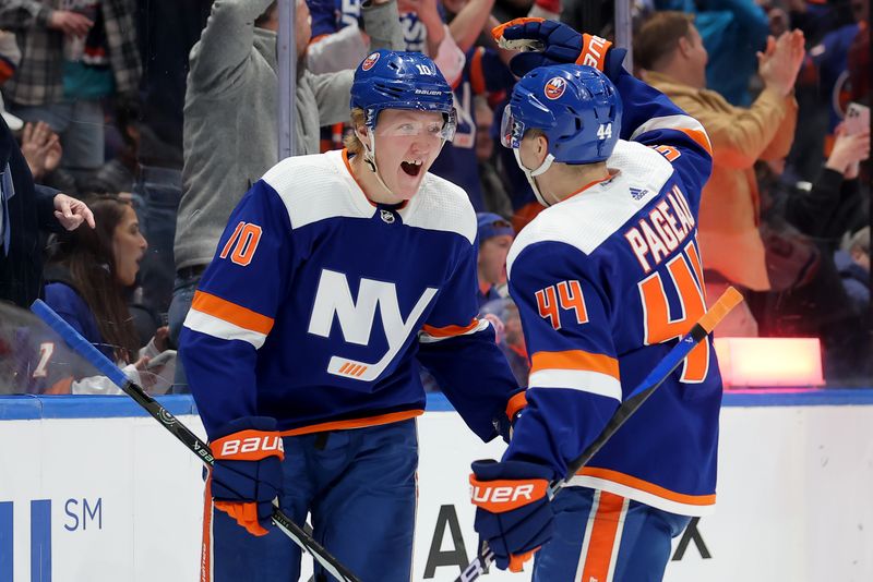 Dec 19, 2023; Elmont, New York, USA; New York Islanders right wing Simon Holmstrom (10) celebrates his short handed goal against the Edmonton Oilers with center Jean-Gabriel Pageau (44) during the second period at UBS Arena. Mandatory Credit: Brad Penner-USA TODAY Sports