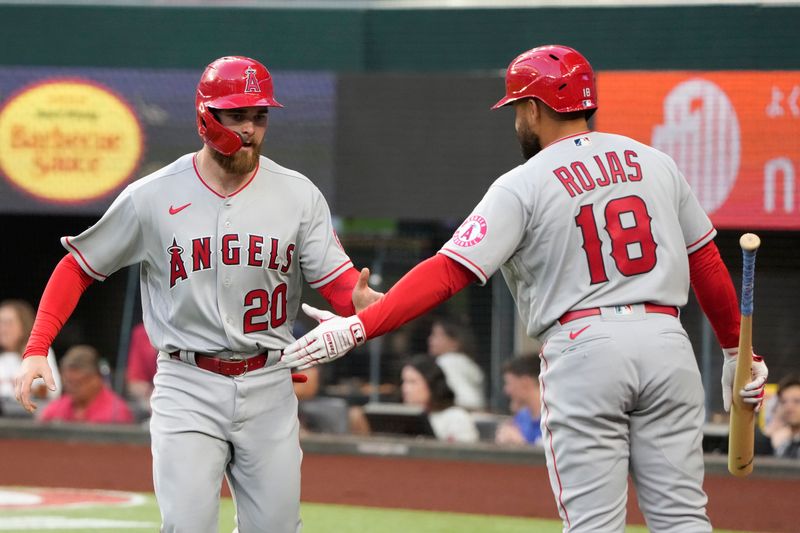 Apr 14, 2022; Arlington, Texas, USA; Los Angeles Angels first baseman Jared Walsh (20) celebrates his run scored with right fielder Jose Rojas (18) against the Texas Rangers during the first inning of a baseball game at Globe Life Field. Mandatory Credit: Jim Cowsert-USA TODAY Sports