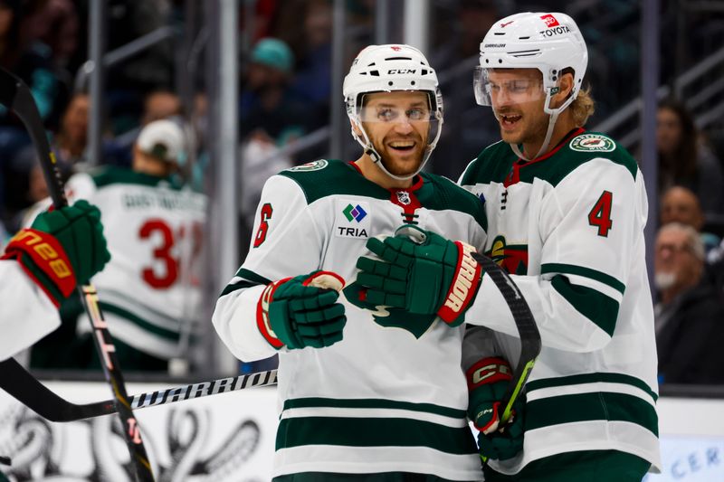 Feb 24, 2024; Seattle, Washington, USA; Minnesota Wild defenseman Dakota Mermis (6) celebrates with defenseman Jon Merrill (4) after scoring a goal against the Seattle Kraken during the second period at Climate Pledge Arena. Mandatory Credit: Joe Nicholson-USA TODAY Sports