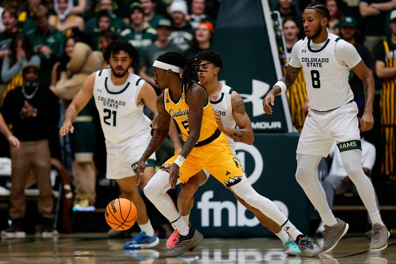 Feb 15, 2025; Fort Collins, Colorado, USA; Wyoming Cowboys guard Obi Agbim (5) controls the ball against Colorado State Rams guard Nique Clifford (10) and forward Rashaan Mbemba (21) and forward Jaylen Crocker-Johnson (8) in the second half at Moby Arena. Mandatory Credit: Isaiah J. Downing-Imagn Images