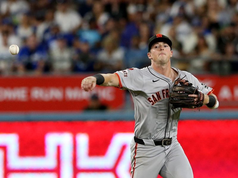 Jul 23, 2024; Los Angeles, California, USA; San Francisco Giants outfielder Tyler Fitzgerald (49) throws to first but is unable to get the runner out during the fifth inning against the Los Angeles Dodgers at Dodger Stadium. Mandatory Credit: Jason Parkhurst-USA TODAY Sports