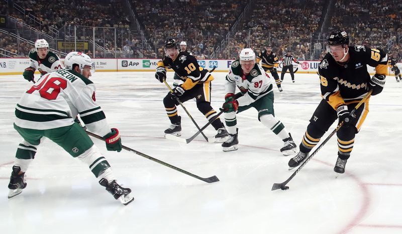 Oct 29, 2024; Pittsburgh, Pennsylvania, USA;  Pittsburgh Penguins center Noel Acciari (55) moves the puck against Minnesota Wild defenseman Jared Spurgeon (46) and left wing Kirill Kaprizov (97) during the first period at PPG Paints Arena. Mandatory Credit: Charles LeClaire-Imagn Images