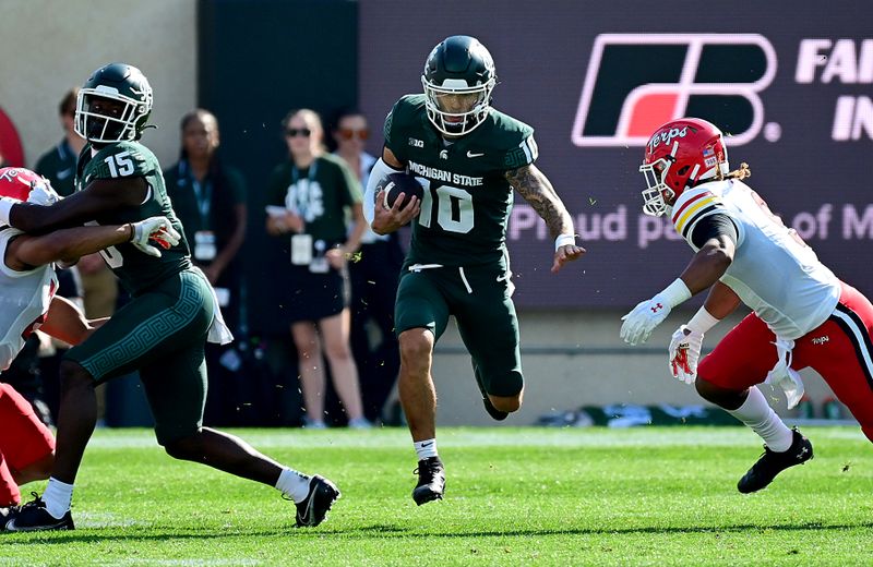 Sep 23, 2023; East Lansing, Michigan, USA;  Michigan State Spartans quarterback Noah Kim (10) avoids a tackle in the first half against the Maryland Terrapins at Spartan Stadium. Mandatory Credit: Dale Young-USA TODAY Sports