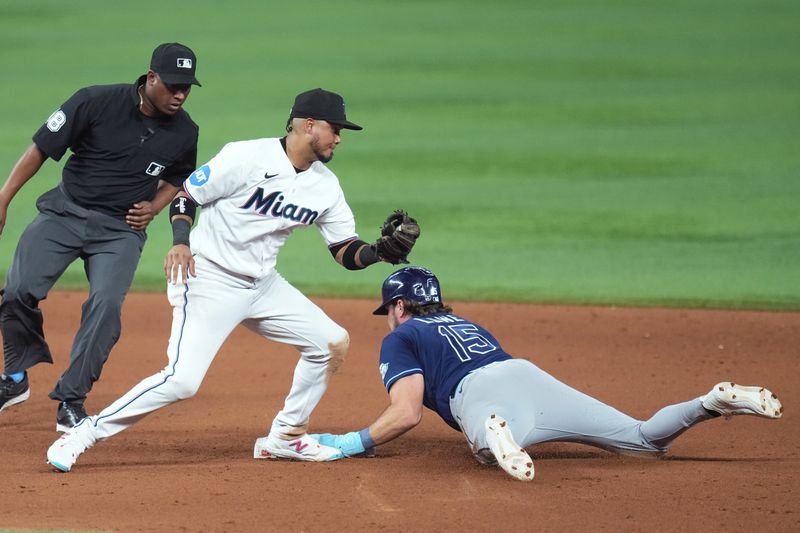 Aug 30, 2023; Miami, Florida, USA; Tampa Bay Rays right fielder Josh Lowe (15) steals second base in the tenth inning as Miami Marlins second baseman Luis Arraez (3) applies the late tag at loanDepot Park. Mandatory Credit: Jim Rassol-USA TODAY Sports